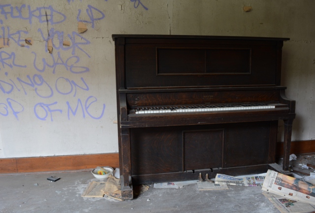 Upright piano in good condition sitting inside vadelized room